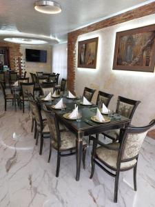 JOKSIM Rooms&Restaurant في Kuršumlija: غرفة طعام مع طاولة طويلة وكراسي