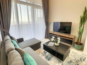 a living room with a couch and a tv at Key View - Golf Vita in Dubai Marina