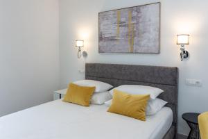 1 dormitorio con cama blanca y almohadas amarillas en "Casa Mia" Luxury villa with heated swimming pool with jacuzzi en Šestanovac