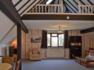 een woonkamer met een loft met een trap bij Greenwood Cottage in Sandown