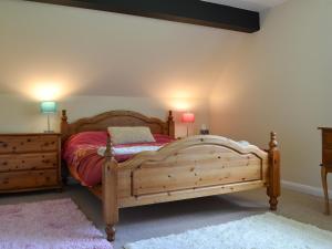 een slaapkamer met een houten bed en 2 lampen bij Greenwood Cottage in Sandown