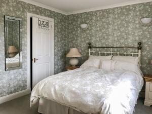 um quarto com uma cama com papel de parede floral em Capelrig em Balfron