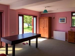 een kamer met een tafel in een kamer met roze muren bij Greenwood Cottage in Sandown