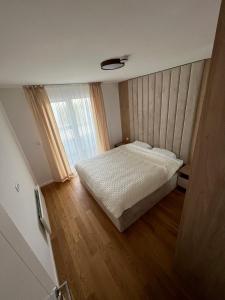 um pequeno quarto com uma cama e uma janela em apartman Lara em Jahorina