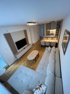 uma sala de estar com um sofá e uma mesa em apartman Lara em Jahorina