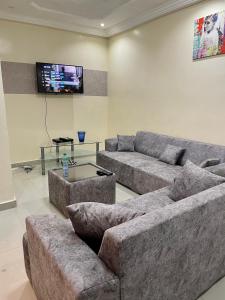 uma sala de estar com 2 sofás e uma televisão de ecrã plano em GHEST HOUSE BASS em Dakar
