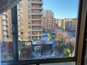 une fenêtre avec vue sur une ville avec des bâtiments dans l'établissement Gijon center, à Gijón