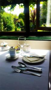 a table with plates and utensils and a glass at Miltons Country Lodge in Langford