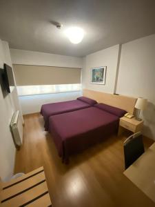 A bed or beds in a room at Hotel Escuela Madrid