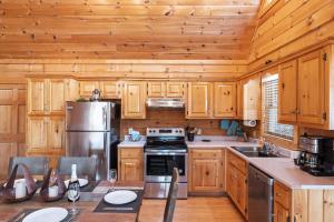 una cucina con armadi in legno e frigorifero in acciaio inossidabile di SunnySierra Cabin a Sevierville