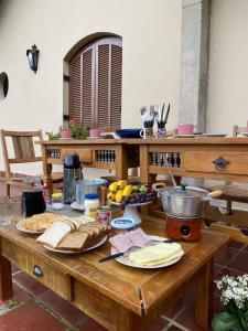 una mesa de madera con pan y fruta. en CANTINHO DO SOSSEGO, en Campos do Jordão