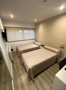 A bed or beds in a room at Hotel Escuela Madrid