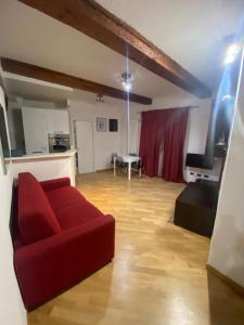ボローニャにあるB&B and Home La Piazzetta della Pioggiaの赤いソファとテーブルのあるリビングルーム