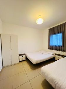 een hotelkamer met 2 bedden en een raam bij King David Apartment in Netanya