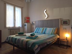 a bedroom with a large bed with towels on it at Casa Alderotti in Bologna