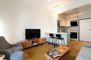 ein Wohnzimmer mit einem TV und einer Küche in der Unterkunft Luxury Home near Edem Beach in Athen
