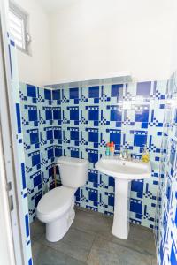 Aquaville Dorado Moderna Villa 4 في دورادو: حمام ازرق وابيض مع مرحاض ومغسلة