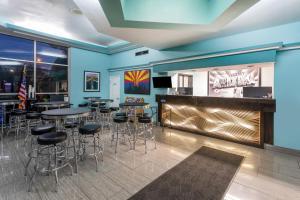 un bar avec des tables et des tabourets dans un restaurant dans l'établissement Super 8 by Wyndham NAU/Downtown Conference Center, à Flagstaff