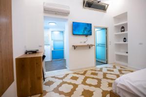 um quarto com uma cama, uma secretária e uma televisão em צימר סבא רבא - Saba Raba B&B em Ein Kinya