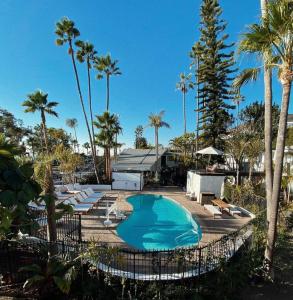 a swimming pool with lounge chairs and palm trees at Laguna Beach Lodge in Laguna Beach