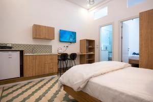 um quarto com uma cama e uma cozinha com uma televisão em צימר סבא רבא - Saba Raba B&B em Ein Kinya