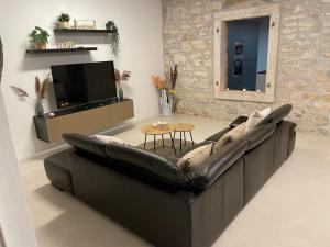 salon ze skórzaną kanapą i telewizorem w obiekcie Villa Makale w mieście Umag