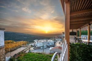 uma vista para o pôr-do-sol a partir da varanda de uma casa em צימר סבא רבא - Saba Raba B&B em Ein Kinya