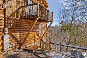 a wooden cabin with a staircase on the side of it at SunnySierra Cabin in Sevierville