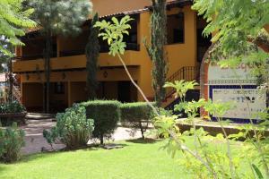 a garden in front of a yellow building at Villas Lupita in Mazamitla