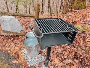 a barbecue grill with a bucket and a barrel at SunnySierra Cabin in Sevierville