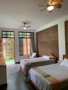 1 dormitorio con 2 camas y ventilador de techo en Alojamiento Familiar Custodia, en Tarapoto