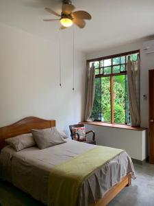 1 dormitorio con 1 cama con ventilador y ventana en Alojamiento Familiar Custodia, en Tarapoto