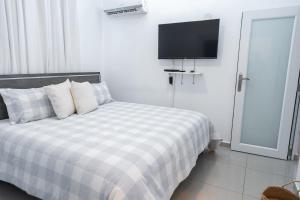 a bedroom with a bed with a tv on the wall at Aquaville Dorado Moderna Villa 4 in Dorado