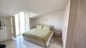 a bedroom with a bed with a green comforter at TDC Home in Vallo della Lucania