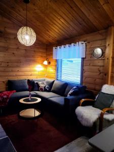 uma sala de estar com um sofá azul e uma janela em Vuosselintähti 8 B em Ruka