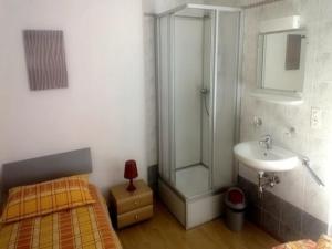 baño con ducha, cama y lavamanos en Ristorante Dosso, en Sigirino