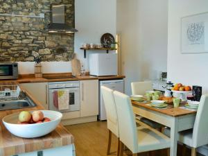 a kitchen with a table with a bowl of fruit on it at Meadowside Forge in Ashwater