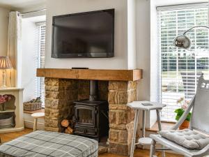 un soggiorno con camino e TV a schermo piatto sopra di esso di Bathurst Cottage a Scarcliffe