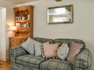 kanapę z poduszkami w salonie w obiekcie Bathurst Cottage w mieście Scarcliffe
