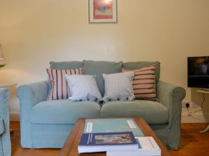 a living room with a blue couch with pillows at South Lodge in Forgandenny