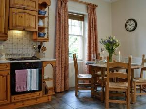 a kitchen and dining room with a table and a window at South Lodge in Forgandenny