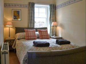 a bedroom with a bed with two pillows on it at South Lodge in Forgandenny