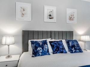 ein Schlafzimmer mit einem Bett mit blauen Kissen und zwei Lampen in der Unterkunft North Lodge Cottage in Chester-le-Street