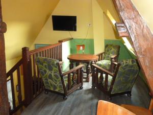 a room with a table and chairs and a television at Les Granges Du Bout De La Ville in Montville