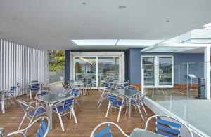 a patio with tables and chairs on a deck at Hotel Boa Vista in Viveiro