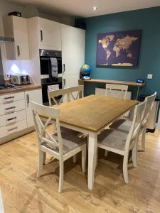 een keuken en eetkamer met een houten tafel en stoelen bij Coastal house in Havant