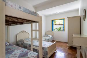 1 dormitorio con 2 literas y escritorio en Casa Praia do Forte, en Cabo Frío