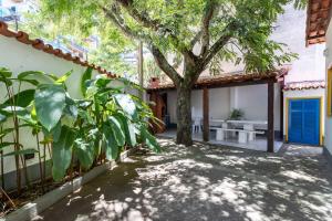 un patio con un árbol y un banco blanco en Casa Praia do Forte, en Cabo Frío