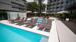 um grupo de cadeiras sentadas ao lado de uma piscina em Marambaia Hotel e Convenções em Balneário Camboriú