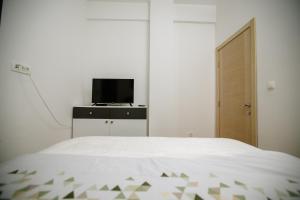 a bedroom with a bed and a tv on a dresser at Apartman Niksic-Maksim in Nikšić